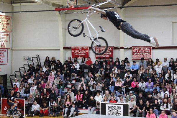 One of four BMX riders on the No Hate Tour flies off the 8-foot ramp set up in the gym on Tuesday